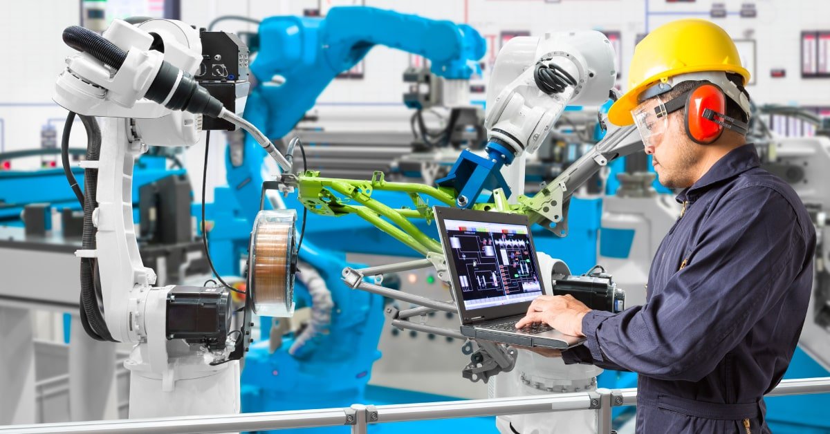 Hombre utilizando la IA en el entorno laboral para programar un brazo mecánico en una fábrica
